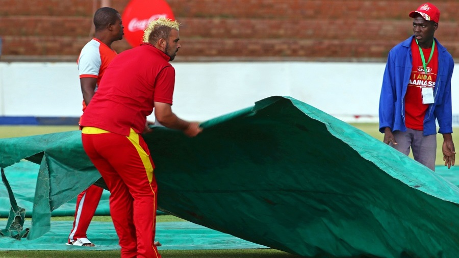 Groundstaff cover the ground with a tarpaulin after rain delayed the fourth tri-nation One Day International (ODI) cricket match between Zimbabwe and West Indies at Queens Sports Club in Bulawayo on November 21, 2016. / AFP / Jekesai Njikizana        (Photo credit should read JEKESAI NJIKIZANA/AFP/Getty Images)