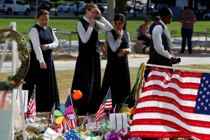 Youths in traditional clothing look at a makeshift memorial for the Pulse nightclub mass shooting victims last week in Orlando, Florida, U.S., June 21, 2016.  REUTERS/Carlo Allegri