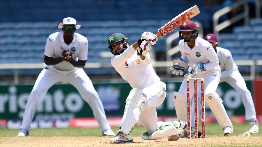 Pakistan's captain Misbah-ul-Haq hits a boundary to score the winning runs as his West Indies' counterpart Jason Holder (L) and wicketkeeper Shane Dowrich (R) watch, on the final day of the first Test match between West Indies and Pakistan at the Sabina Park in Kingston, Jamaica, on April 25, 2017.  Pakistan defeated West Indies by 7 wickets to lead the three-Test-match series 1-0.  / AFP PHOTO / Jewel SAMAD