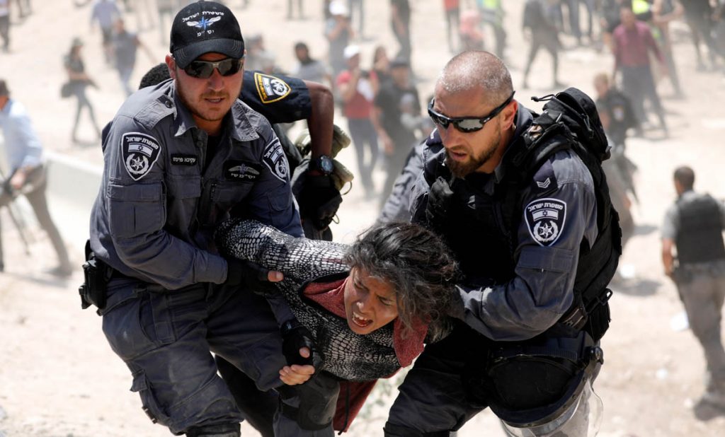Israeli policemen detain a Palestinian girl in the Palestinian Bedouin village of al-Khan al-Ahmar near Jericho in the occupied West Bank July 4, 2018. REUTERS/Mohamad Torokman - RC1B2BE679F0