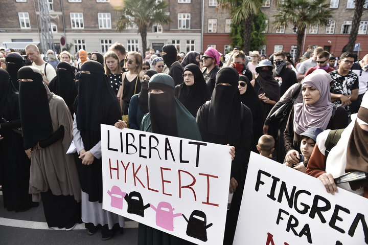 Women wearing niqab to veil their faces take part in a demonstration on August 1, 2018, the first day of the implementation of the Danish face veil ban, in Copenhagen, Denmark. - Denmark's controversial ban on the Islamic full-face veil in public spaces came into force as women protested the new measure which fines anyone wearing the garment. Human rights campaigners have slammed the ban as a violation of women's rights, while supporters argue it enables better integration of Muslim immigrants into Danish society. (Photo by Mads Claus Rasmussen / Ritzau Scanpix / AFP) / Denmark OUT (Photo credit should read MADS CLAUS RASMUSSEN/AFP/Getty Images)