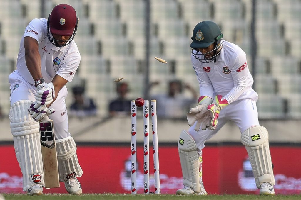 West Indies' Kieran Powell (L) is bowled out during the second day of the second Test cricket match between Bangladesh and West Indies in Dhaka on December 1, 2018. (Photo by Salahuddin Ahmed / AFP)