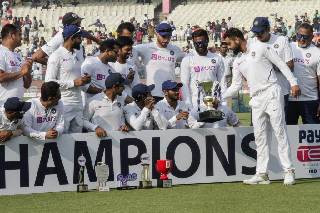 India's captain Virat Kohli hands over the winning trophy to teammates prior to a photo session after the second test cricket match between India and Bangladesh, in Kolkata, India, Sunday, Nov. 24, 2019. (AP Photo/Bikas Das)
