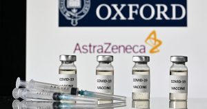 An illustration picture shows vials with Covid-19 Vaccine stickers attached and syringes, with the logo of the University of Oxford and its partner British pharmaceutical company AstraZeneca, on November 17, 2020. (Photo by JUSTIN TALLIS / AFP)